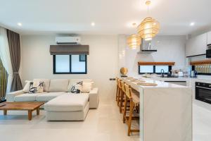 a kitchen and living room with a couch and a table at Siva Pool Villa in Chaloklum