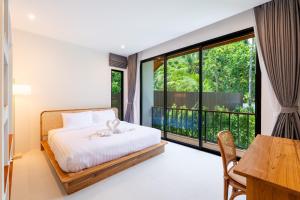 a bedroom with a bed and a large window at Siva Pool Villa in Chaloklum