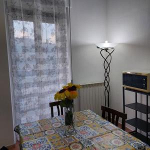 a dining room table with a vase of flowers on it at Chiaro di Luna in Crispiano