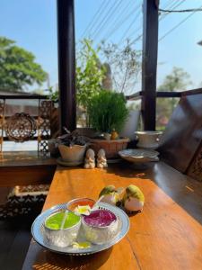 a wooden table with a plate of food on it at Chom Wat Boutique Hotel in Ban Hau Chang
