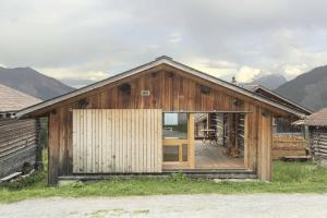 a small wooden house with a large sliding glass door at Stylish architects hut ski lift in Mutten