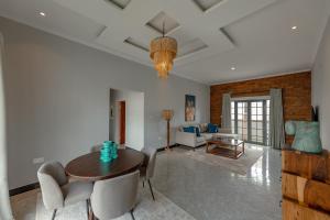 a living room with a table and chairs and a couch at Paris Royal Estate in Lusaka +10 photos