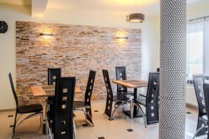 a restaurant with tables and chairs in front of a brick wall at Willa Danielski in Niedzica
