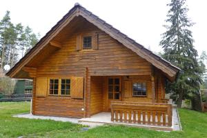 a small log cabin with a porch and windows at Ferienhaus Großmann in Drognitz
