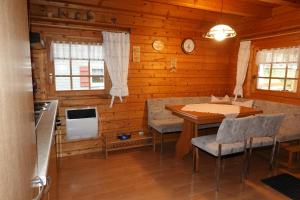a kitchen with a table and chairs in a cabin at Ferienhaus Großmann in Drognitz