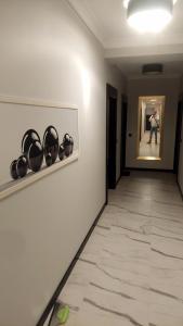 a hallway with black bowls on the wall and a person in a painting at MagMar Studio Kluczbork Rynek Premium in Kluczbork