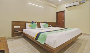 a bedroom with a large white bed with colorful pillows at Hotel Rama Hindustani in Jaipur