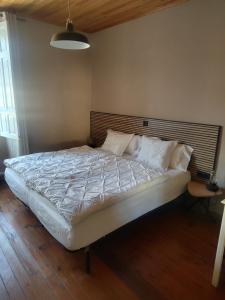 a bedroom with a large bed with white sheets and pillows at Pension Casa Simon in Treacastela