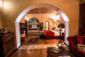 a bedroom with an archway with a bed and a couch at CCR Cappadocia Cave Resort &Spa in Eskiömerler