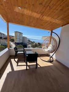 a room with a table and chairs on a balcony at Elti Apartment in Sarandë