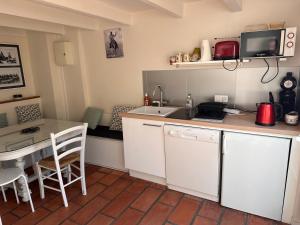 a small kitchen with a sink and a table at La Saline in Aigues-Mortes