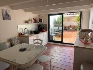 a kitchen with a table and a kitchen with a patio at La Saline in Aigues-Mortes +11 photos