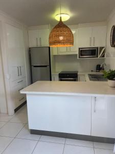 a kitchen with white cabinets and a white counter top at Nautilus Noosa Resort in Noosaville