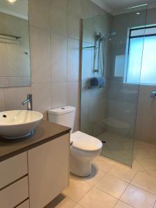 a bathroom with a toilet and a sink and a shower at Nautilus Noosa Resort in Noosaville +150 photos