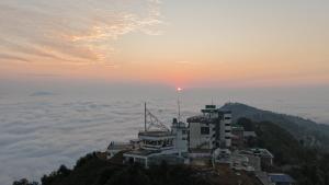 a building on top of a mountain in the clouds at Pokhara Heights Resort Pvt Ltd in Pokhara