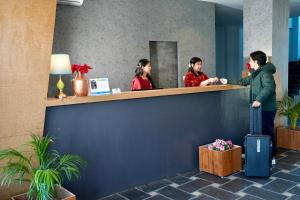 a man standing at a counter in a lobby at Pokhara Heights Resort Pvt Ltd in Pokhara