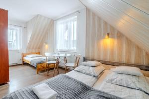 a bedroom with two beds and a table at Willa Danielski in Niedzica