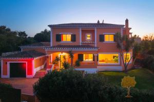 a large house with its lights on at "Orange Tree Villa in Alvor - South - facing Family Villa with Private Poll" in Alvor