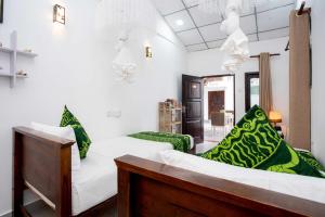 a room with two white beds and green pillows at Glamour Mirissa in Mirissa +166 photos