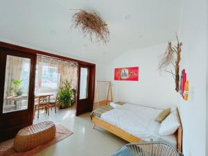 a living room with a bed and a dining room at Làng Kò Hơ hotel in Da Lat