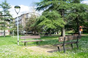 a park with two benches and a light pole at La casetta di Leo in Poggibonsi