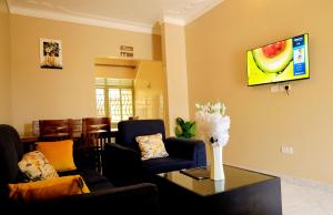 a living room with a couch and a tv on a wall at Two-bedroom unit in Mubende Town in Mubende +25 photos
