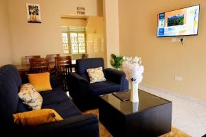 a living room with two blue couches and a table at Two-bedroom unit in Mubende Town in Mubende