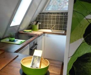 a small kitchen with a green bowl on a table at Nurdachhaus Ferienpark Schellbronn in Schellbronn