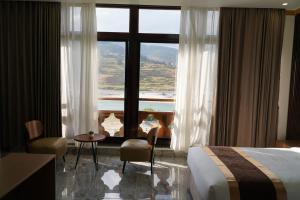 a hotel room with a bed and a large window at Tara Haven Hotel in Yuwak
