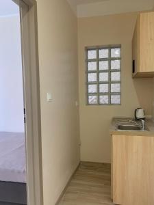 a kitchen with a sink and a window at Pokoje Blisko Morza SUNSET in Ustka +24 photos