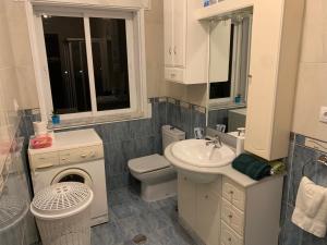 a white bathroom with a sink and a toilet at A Marosa playa in Burela de Cabo