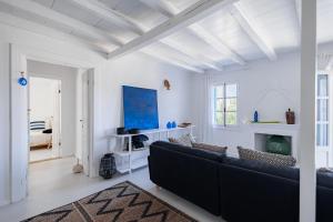 a living room with a black couch and white walls at Casa Calypso in Tselendáta