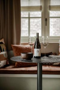 a table with a bottle of wine and two glasses at Le Diez Boutique Hotel in Den Bosch
