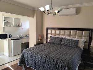 a bedroom with a bed and a kitchen in it at Camdale Guesthouse in Cape Town