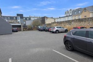 a parking lot with cars parked in front of buildings at Hôtel Villa Des 2 Caps in Wimereux +25 photos