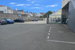 a parking lot with cars parked next to a gate at Hôtel Villa Des 2 Caps in Wimereux