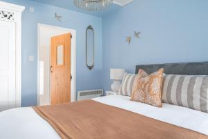 a bedroom with a bed with blue walls at Stunning Cottage with free Spa access in Newby Bridge +50 photos