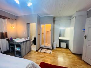 a bedroom with a bed and a bathroom with a sink at Khans Residence in Gqeberha