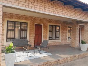 a brick house with two chairs and a patio at Magnolia Hotel in Middelburg