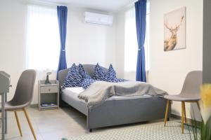 a bedroom with a bed with blue and white pillows at Tótündér Vendégház in Levelek
