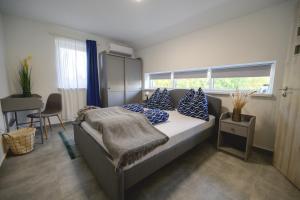 a bedroom with a bed with blue pillows and a window at Tótündér Vendégház in Levelek +29 photos