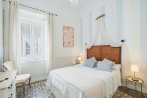 a white bedroom with a bed and a window at Palacete de La Alameda - Adults Only- in Cádiz