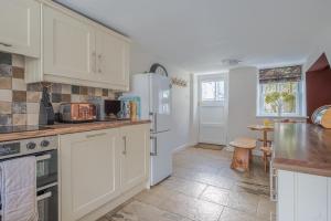 a kitchen with white cabinets and a counter top at Stunning Cottage with free Spa access in Newby Bridge