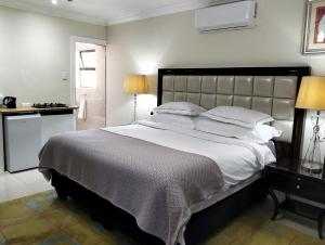 a bedroom with a large bed and a bathroom at Camdale Guesthouse in Cape Town +22 photos