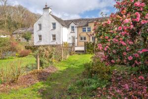 a house with a garden with pink roses at Stunning Cottage with free Spa access in Newby Bridge