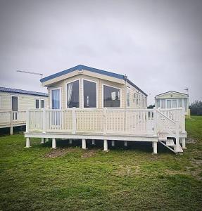 a large white house sitting on a dock at Beach Retreats, Romney Sands, Parkdean Resorts in Greatstone