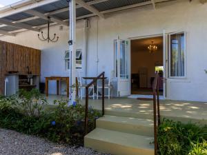 a porch of a home with stairs and a chandelier at Julie's Cottage in Riebeek-Kasteel