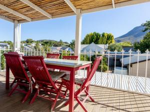 a red table and chairs on a deck at Julie's Cottage in Riebeek-Kasteel +2 photos