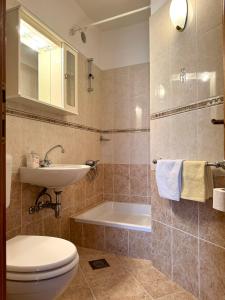 a bathroom with a toilet and a sink and a tub at Apartments Robert in Tučepi +29 photos