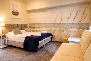 a bedroom with a bed and a couch at SeaSide Sopot - butikowe noclegi przy plaży in Sopot